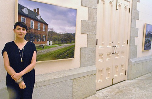 Regina Mamou posing next to one of her photos during the closing reception